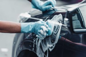washing car with sponge and soap exterior detailing