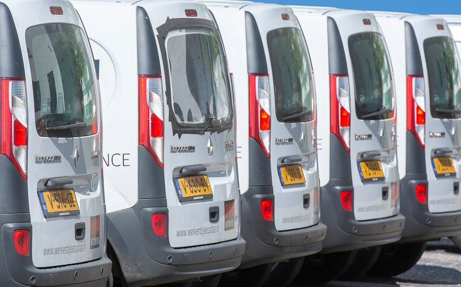 Row of clean white commercial fleet vehicles parked at a New Orleans business lot after professional detailing