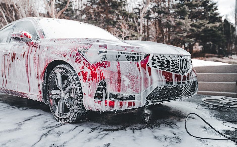 Thick foam from a professional foam cannon covering a vehicle exterior during a pre-wash