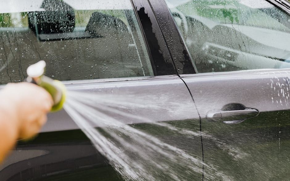 Detailer performing a gentle maintenance wash on a clean sedan in a New Orleans driveway