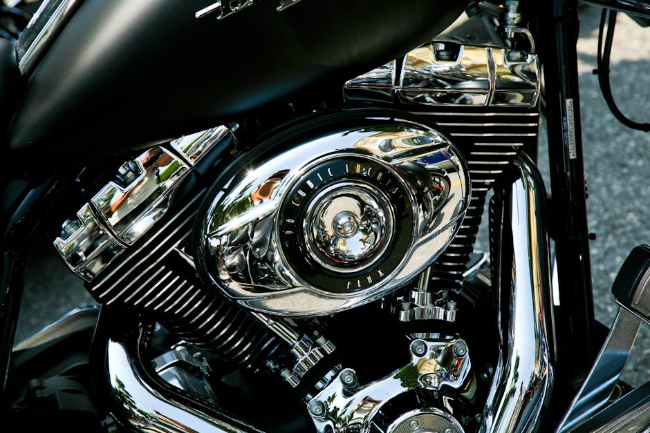 Close-up of a motorcycle's chrome pipes and engine being detailed by hand in New Orleans