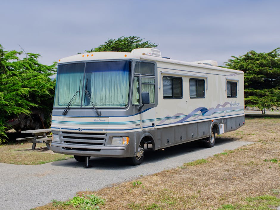 Technician removing black streaks from the side of an RV during mobile detailing in New Orleans