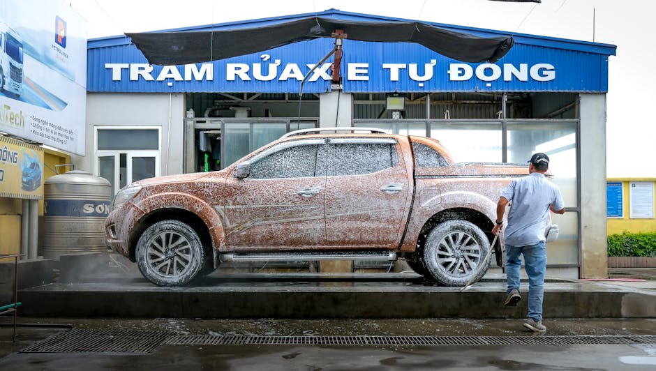 Professional detailer hand-washing a full-size truck in a New Orleans driveway