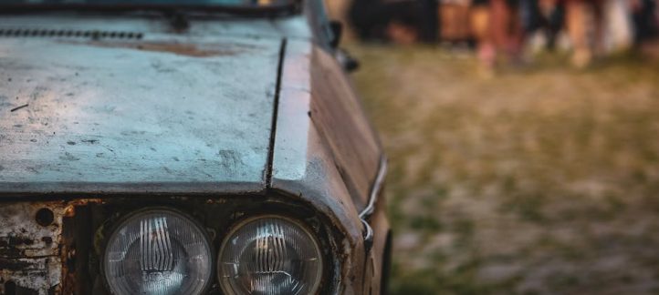 Close-up of a car headlight with visible yellow oxidation and haze on the lens surface