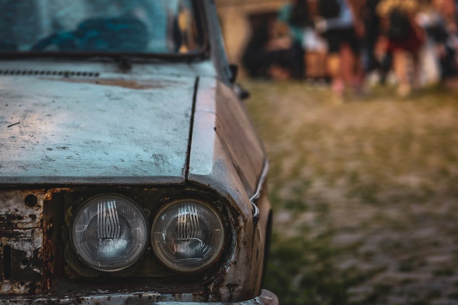 Close-up of a car headlight with visible yellow oxidation and haze on the lens surface